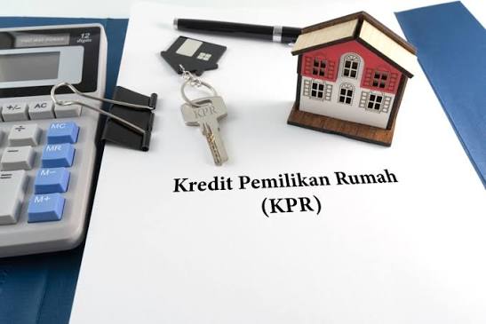 Dokumen Kredit Pemilikan Rumah (KPR) dengan kalkulator, kunci, dan miniatur rumah